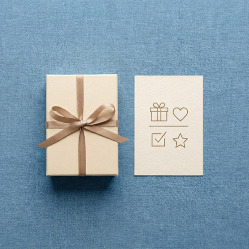 A gift box and a handwritten note on a linen background