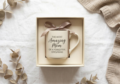 A mug inside a gift box on a blue linen background