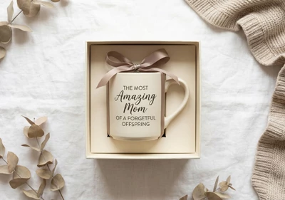 A mug inside a gift box on a blue linen background