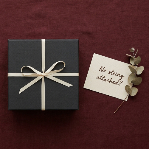 A gift box and a handwritten note on a linen background