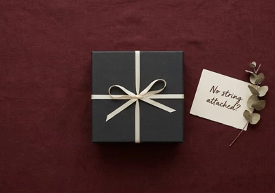 A gift box and a handwritten note on a linen background