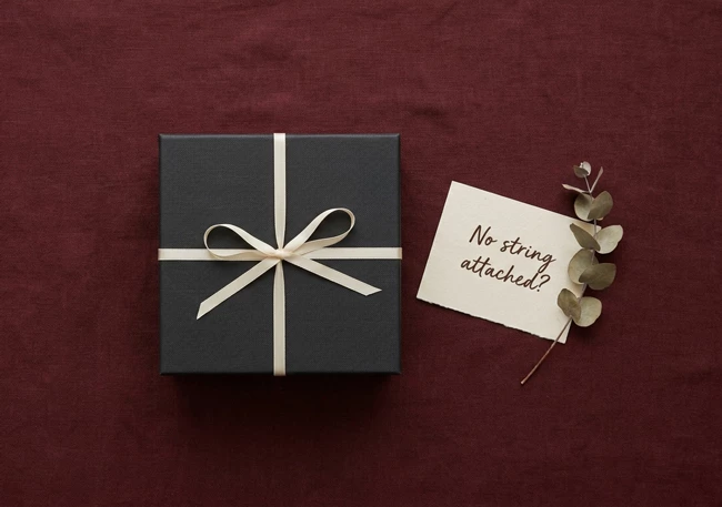 A gift box and a handwritten note on a linen background