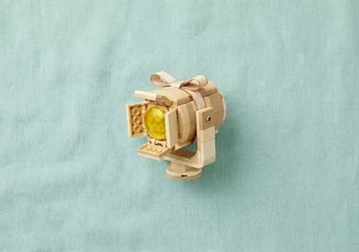 A Spotlight made out of lego inside a gift box on a green linen background